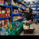 mother-with-her-son-at-a-food-bank-at-a-community-centre-in-england-2J6BW9X
